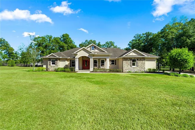 a front view of a house with yard and green space