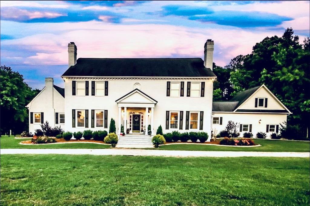 3971 Fairplay Road Madison, GA 30650 - Photo 1 of 1 a front view of a house with a garden and plants