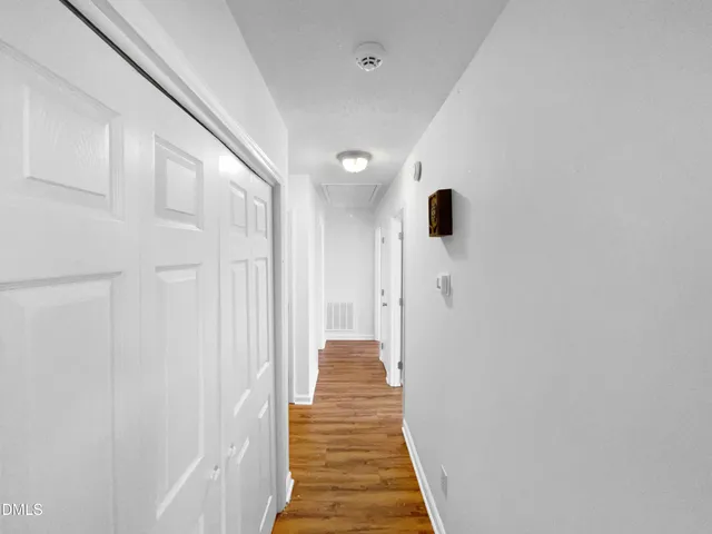 a view of a hallway with wooden floor and staircase
