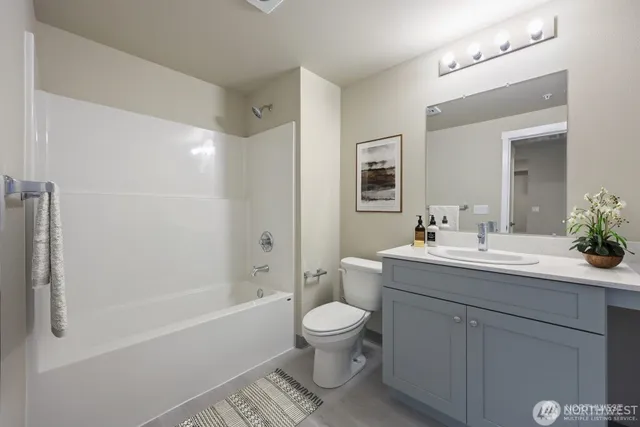 a bathroom with a granite countertop sink toilet a large mirror a bathtub and shower