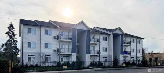 a front view of a building with lot of windows and trees