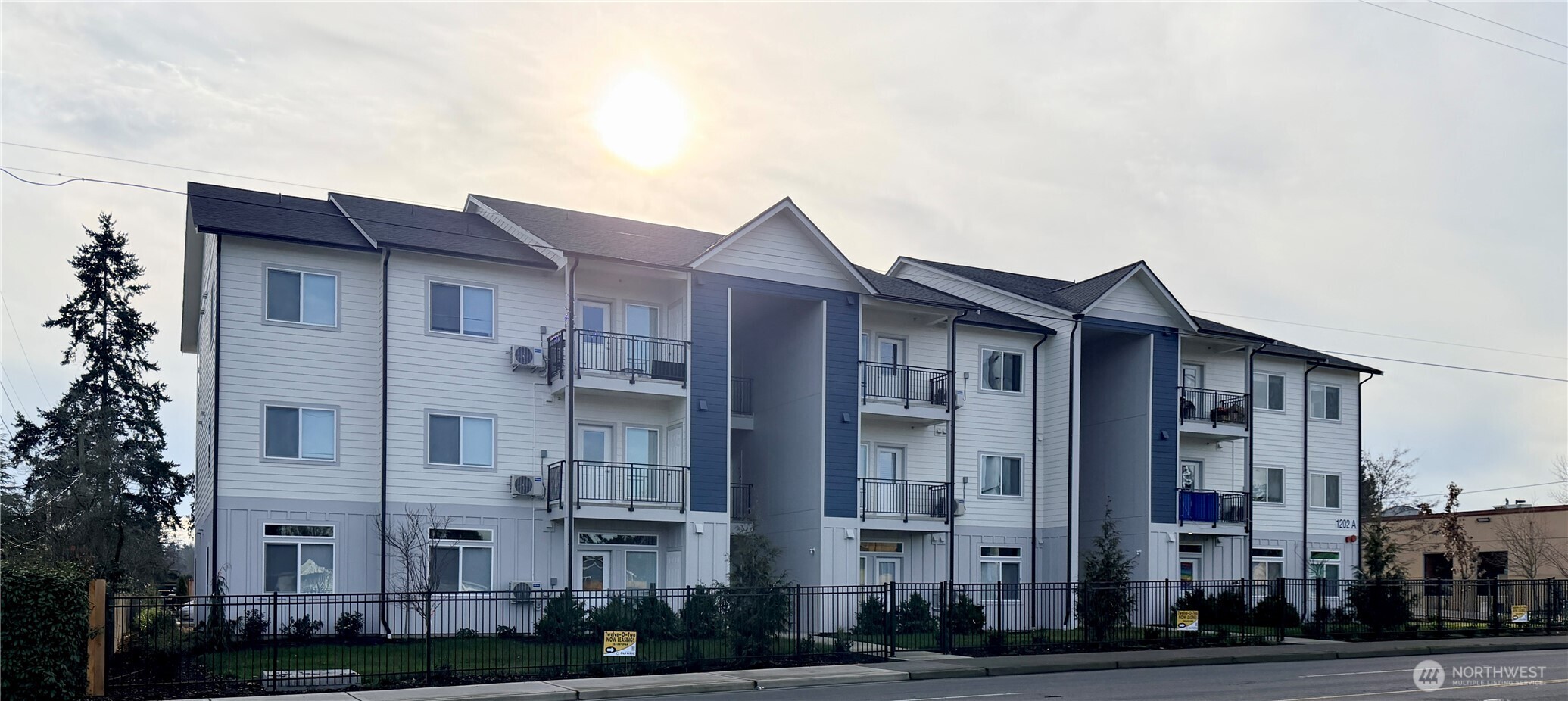 1202 East 72nd Street Tacoma, WA 98404 - Photo 3 of 25 a front view of a building with lot of windows and trees
