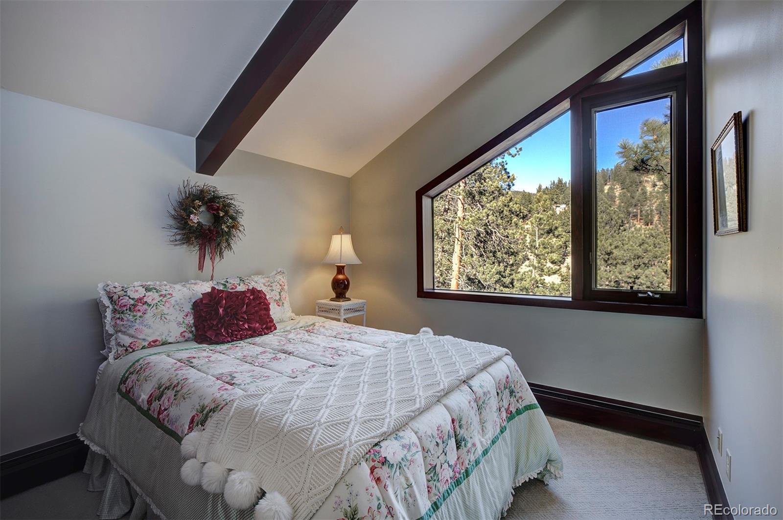 134 Cedar Way Evergreen, CO 80439 - Photo 34 of 40 a bed sitting in a bedroom next to a window