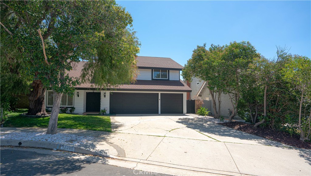 a front view of a house with a yard and trees