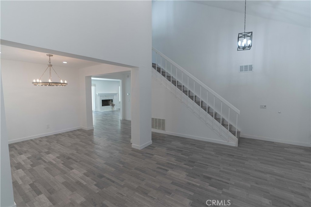 12230 Stewarton Drive Porter Ranch, CA 91326 - Photo 12 of 37 a view of an empty room with wooden floor and stairs