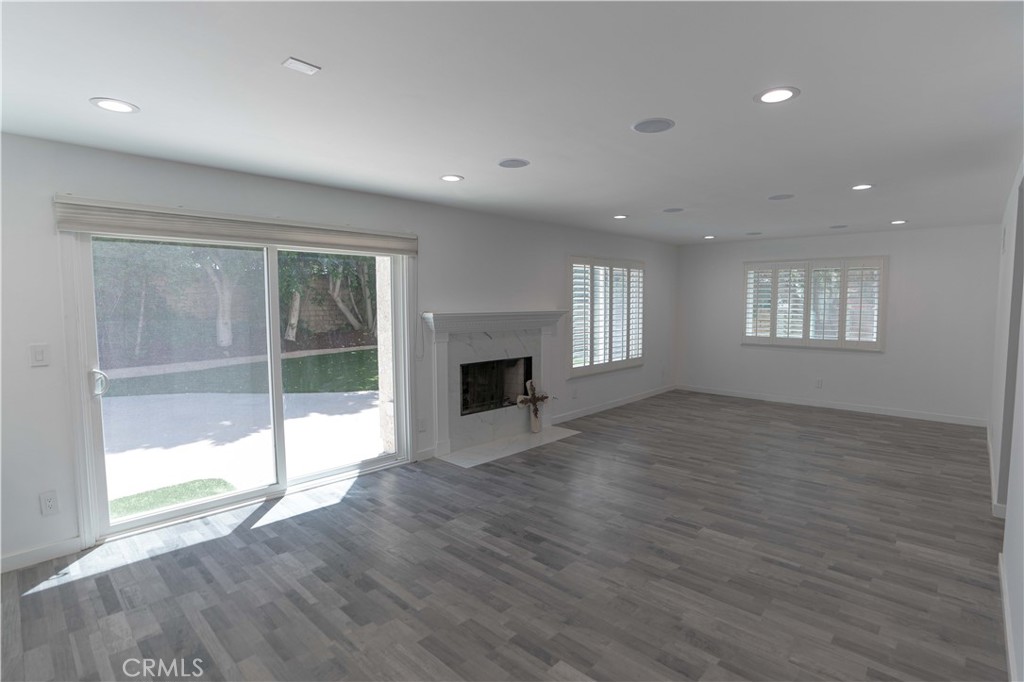 12230 Stewarton Drive Porter Ranch, CA 91326 - Photo 15 of 37 a view of empty room with wooden floor and fireplace