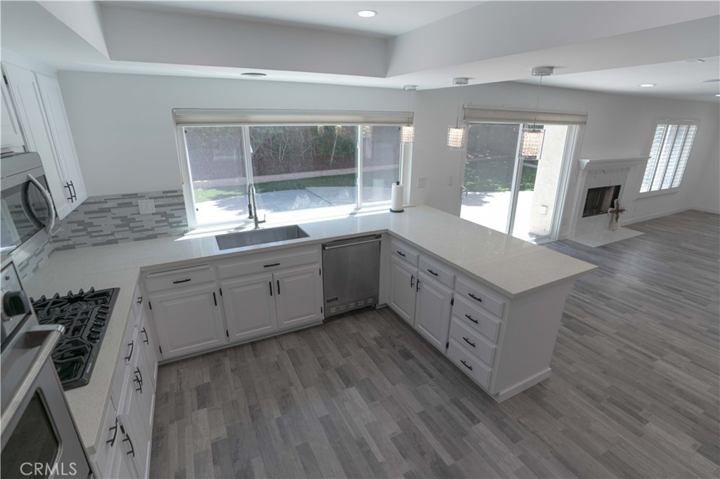 12230 Stewarton Drive Porter Ranch, CA 91326 - Photo 16 of 37 a large white kitchen with a large window