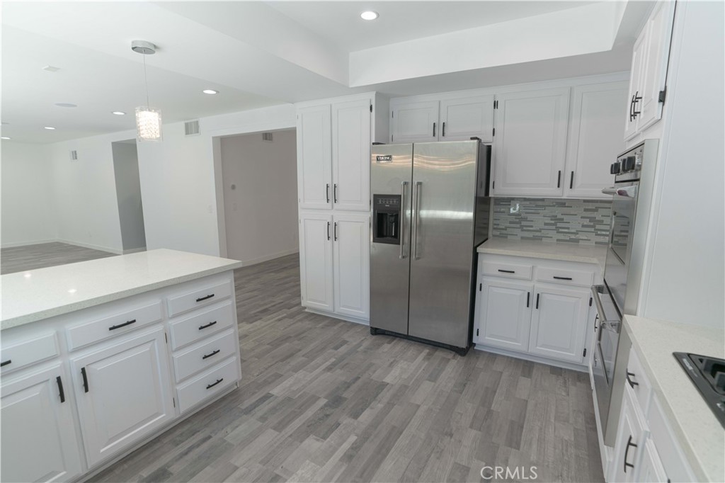 12230 Stewarton Drive Porter Ranch, CA 91326 - Photo 18 of 37 a kitchen with stainless steel appliances a refrigerator sink and cabinets