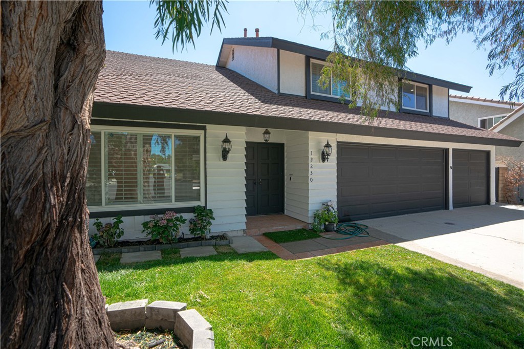 12230 Stewarton Drive Porter Ranch, CA 91326 - Photo 2 of 37 a front view of a house with a garden and plants