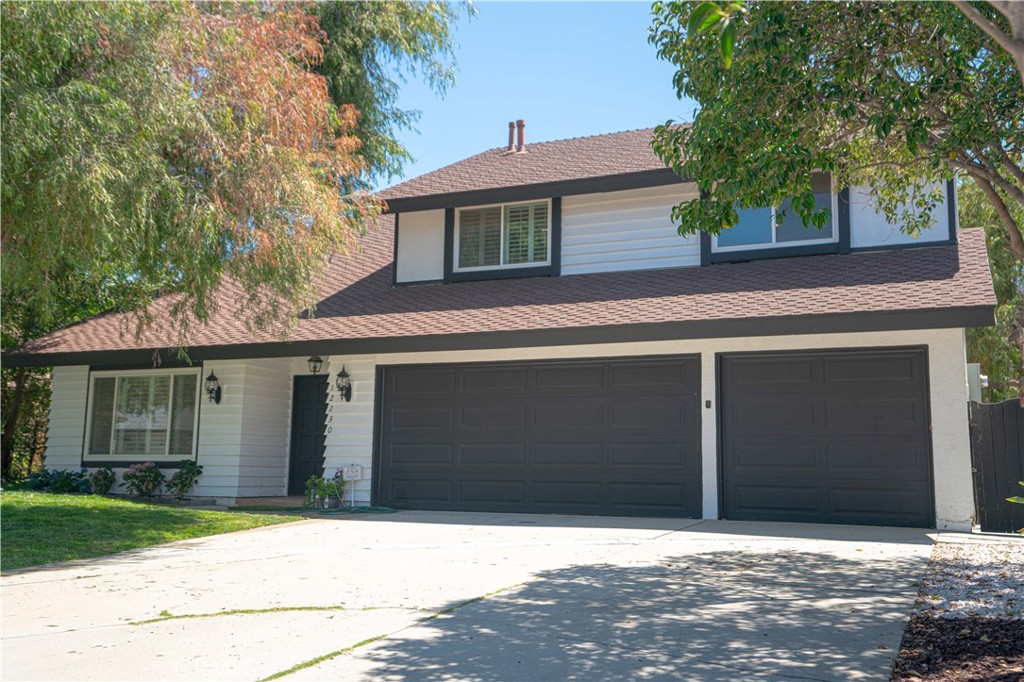 12230 Stewarton Drive Porter Ranch, CA 91326 - Photo 3 of 37 a front view of a house with a yard and garage