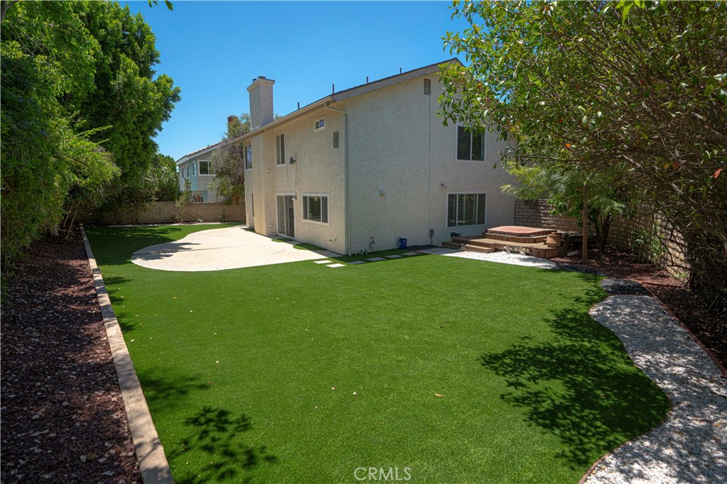 12230 Stewarton Drive Porter Ranch, CA 91326 - Photo 33 of 37 a backyard of a house with table and chairs plants and large tree