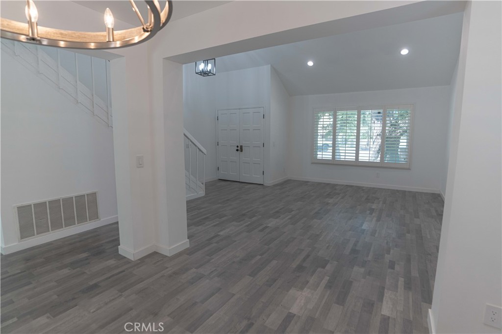 12230 Stewarton Drive Porter Ranch, CA 91326 - Photo 8 of 37 a view of an empty room with wooden floor and a window