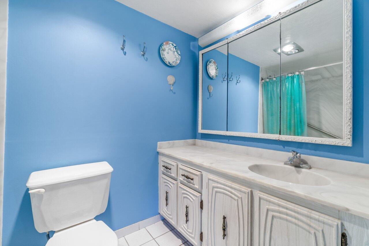 2460 Southwest 22nd Avenue, Unit 809 Delray Beach, FL 33445 - Photo 15 of 27 a bathroom with a sink a toilet and mirror