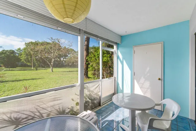 a view of a porch with furniture and a yard