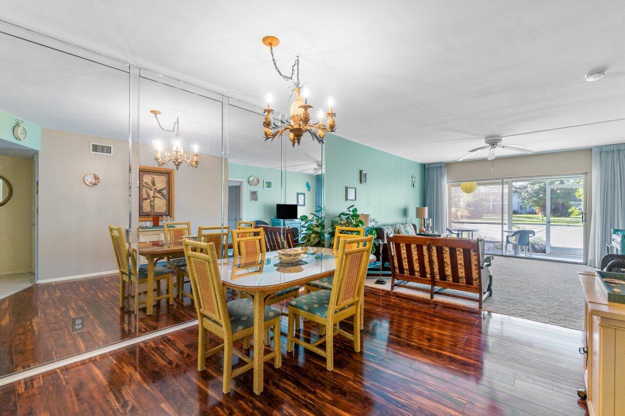 2460 Southwest 22nd Avenue, Unit 809 Delray Beach, FL 33445 - Photo 8 of 27 a view of a dining room with furniture window and wooden floor