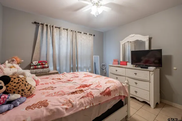 a bedroom with a bed and a flat tv screen on the dresser