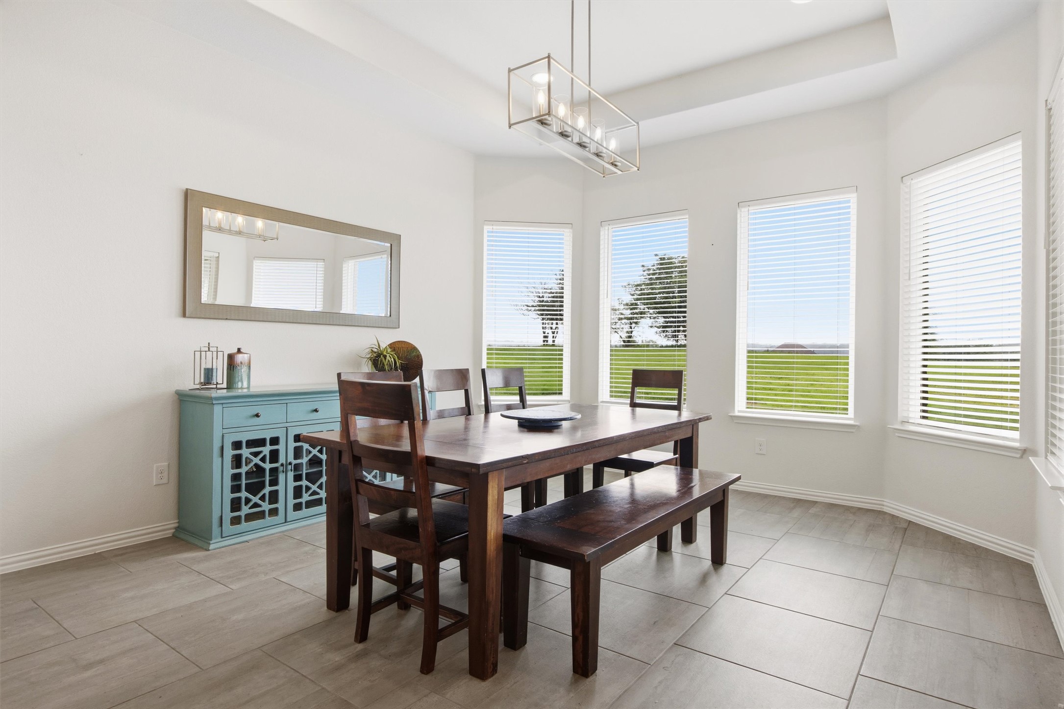 192 Raptor Beak Way Cedar Creek, TX 78612 - Photo 12 of 38 Dining area featuring large windows, tray ceiling, and tile flooring
