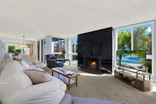 a living room with furniture a large window and a fireplace