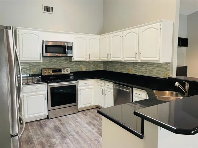 a kitchen with stainless steel appliances granite countertop a stove and a microwave