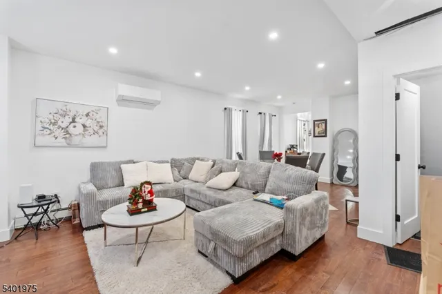 a living room with furniture and a dining table with wooden floor
