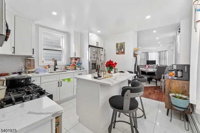 a kitchen with a sink stove and white cabinets with wooden floor