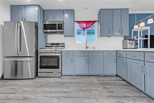 a kitchen with stainless steel appliances a stove microwave and refrigerator