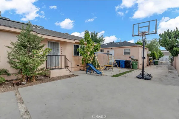 a view of a house with a patio and a yard