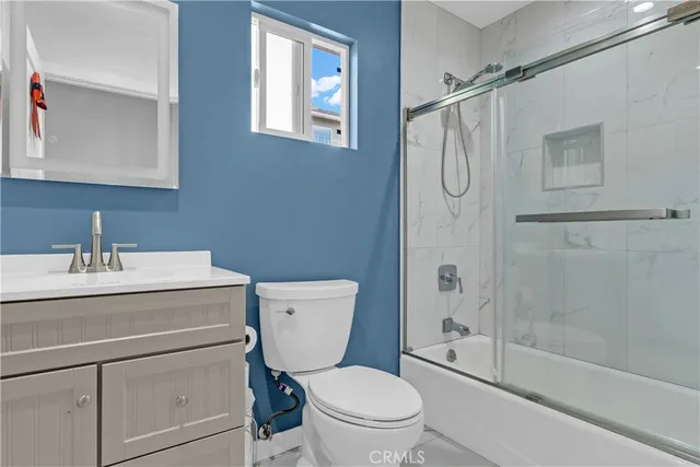 a bathroom with a granite countertop toilet sink and a shower