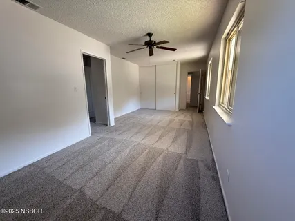 a bedroom with a bed and a dresser next to a window