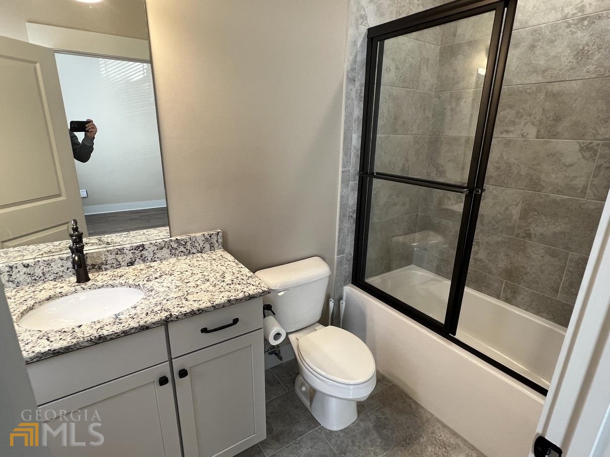 860 South Harkness Street, Unit G Jackson, GA 30233 - Photo 13 of 21 a bathroom with a granite countertop sink toilet and shower