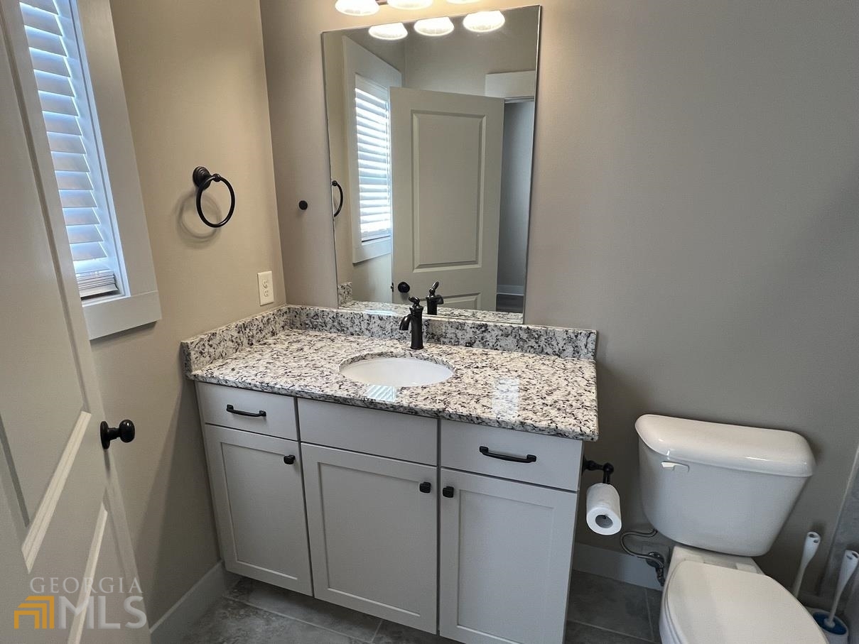 860 South Harkness Street, Unit G Jackson, GA 30233 - Photo 14 of 21 a bathroom with a granite countertop toilet sink and mirror