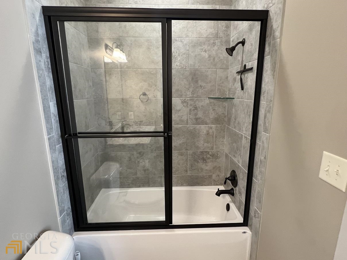 860 South Harkness Street, Unit G Jackson, GA 30233 - Photo 15 of 21 a bathroom with a glass shower door