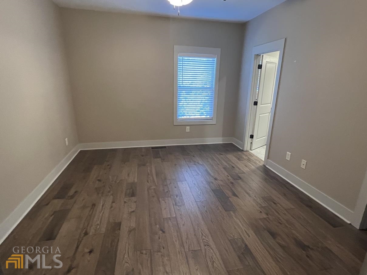 860 South Harkness Street, Unit G Jackson, GA 30233 - Photo 16 of 21 an empty room with wooden floor and windows