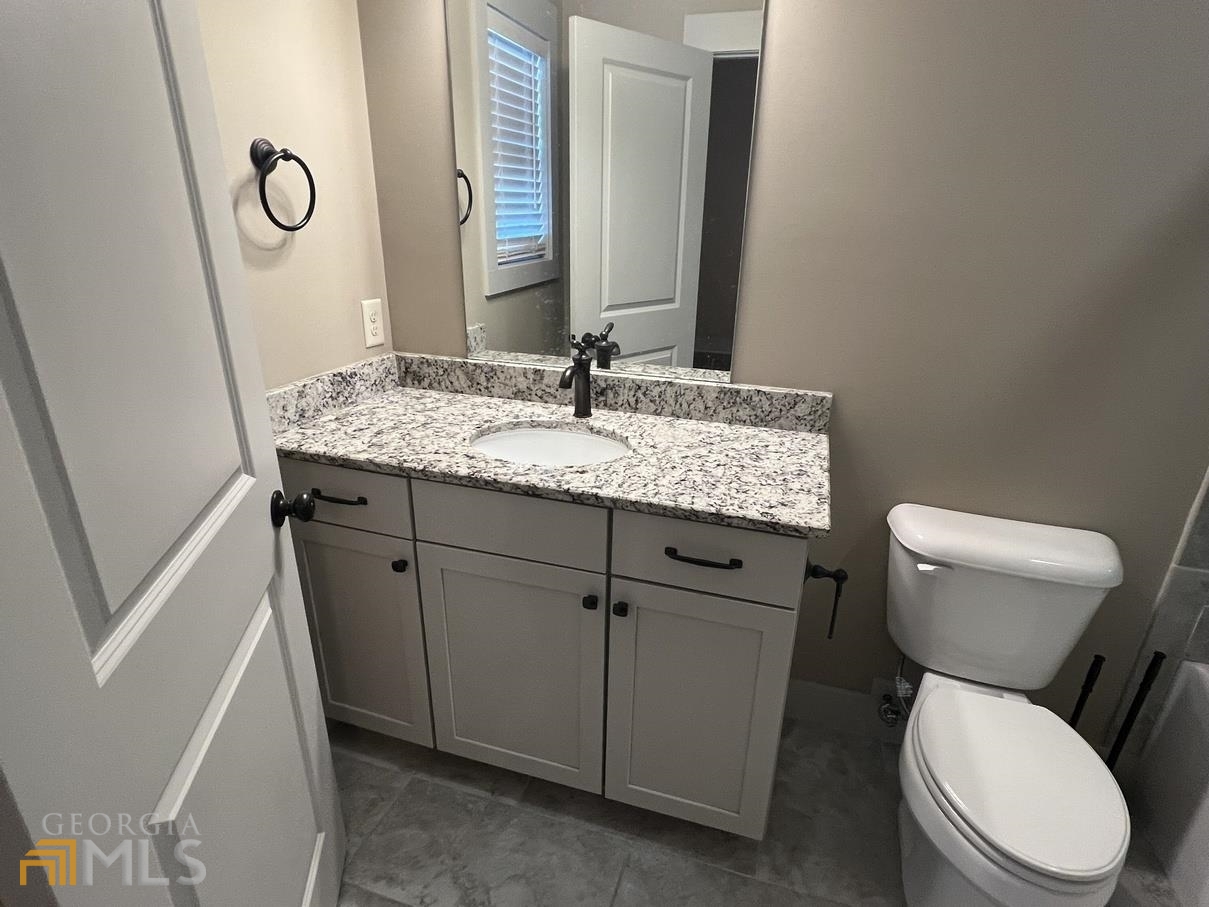 860 South Harkness Street, Unit G Jackson, GA 30233 - Photo 18 of 21 a bathroom with a granite countertop toilet sink and mirror