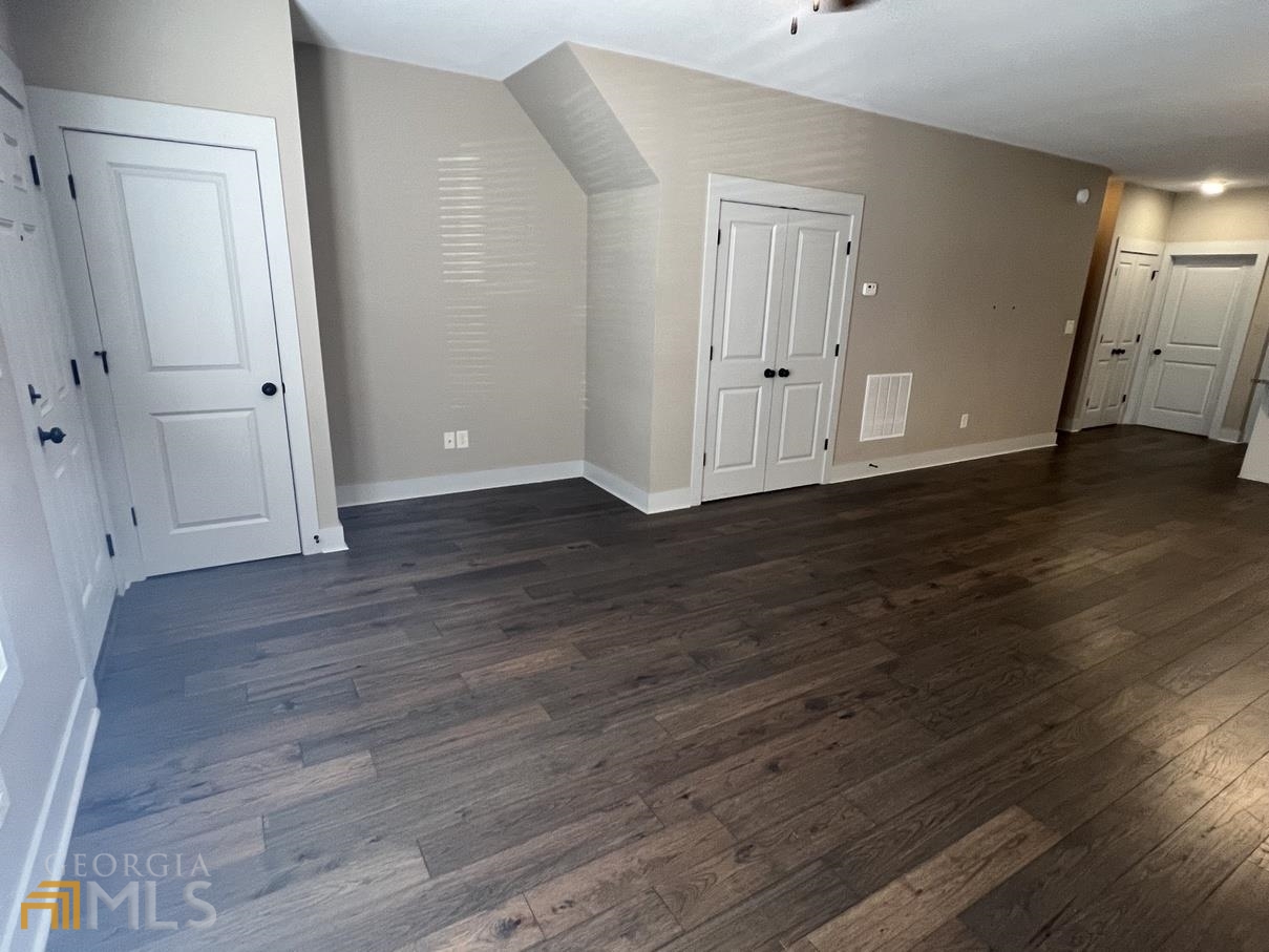 860 South Harkness Street, Unit G Jackson, GA 30233 - Photo 3 of 21 an empty room with wooden floor and closet