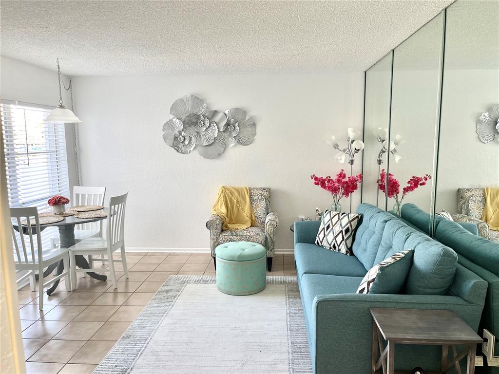 165 Medallion Boulevard, Unit H Madeira Beach, FL 33708 - Photo 11 of 20 a living room with furniture and a potted plant
