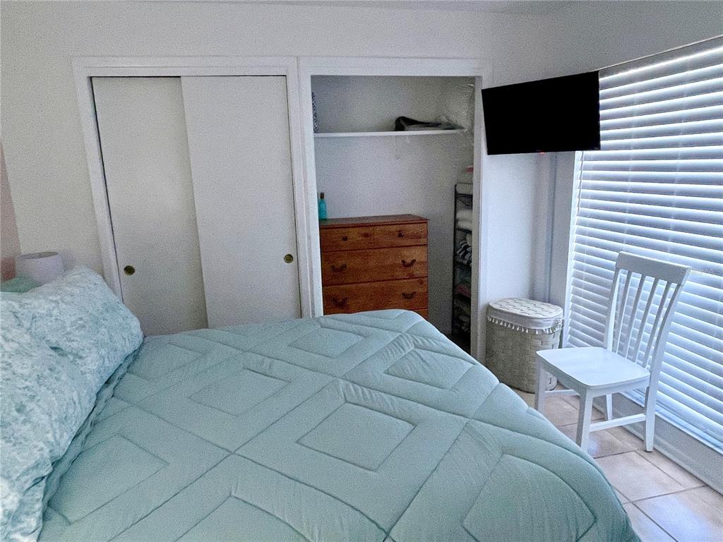 165 Medallion Boulevard, Unit H Madeira Beach, FL 33708 - Photo 14 of 20 a bedroom with a bed and a television