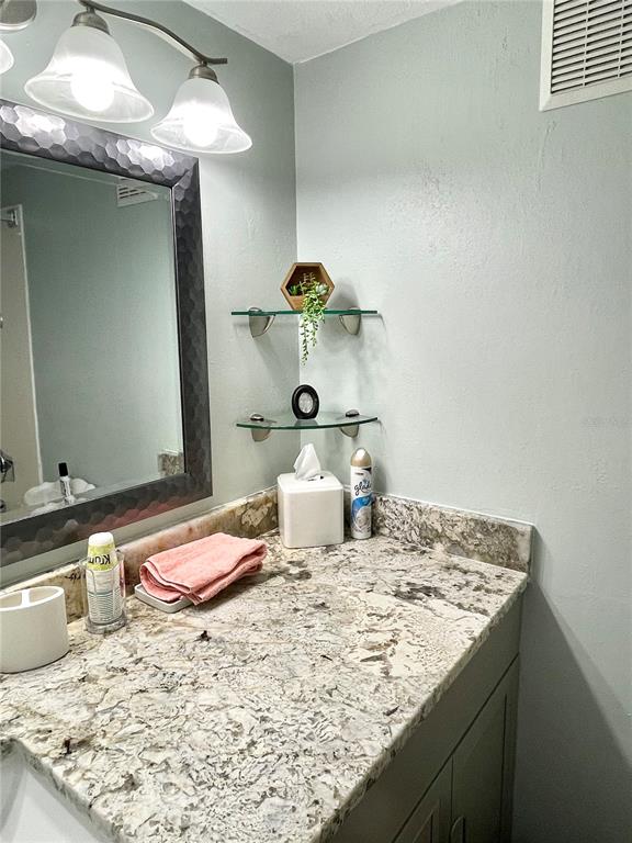 165 Medallion Boulevard, Unit H Madeira Beach, FL 33708 - Photo 20 of 20 a bedroom with a bed and a chandelier