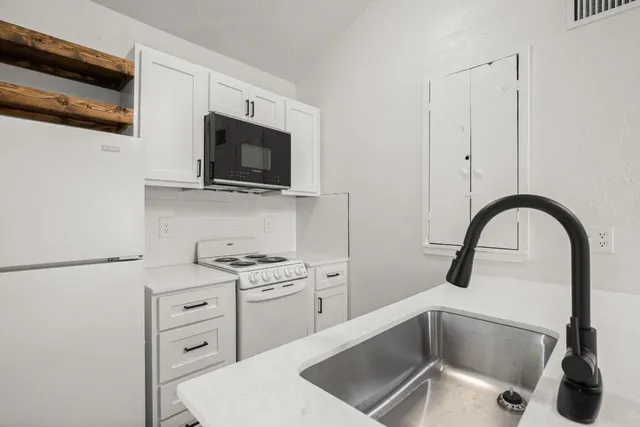 a kitchen with stainless steel appliances kitchen island a white stove top oven and sink