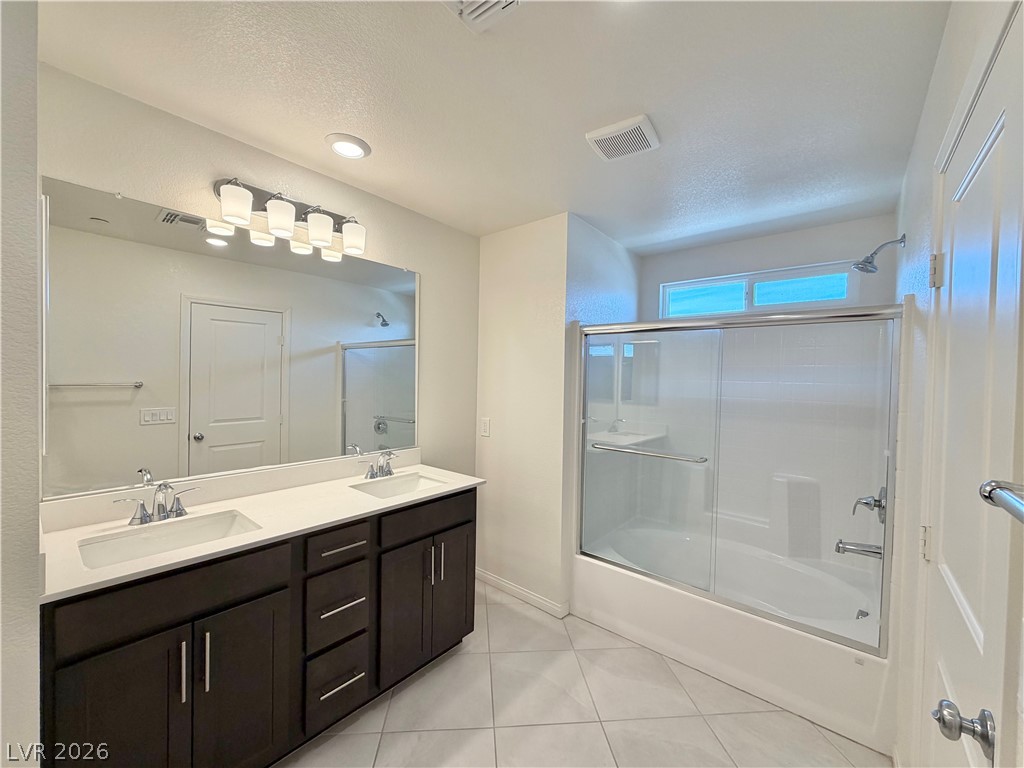 3624 Bitonto Lane Henderson, NV 89044 - Photo 17 of 28 This bathroom features a double vanity and a shower-tub combo, blending convenience with modern design.