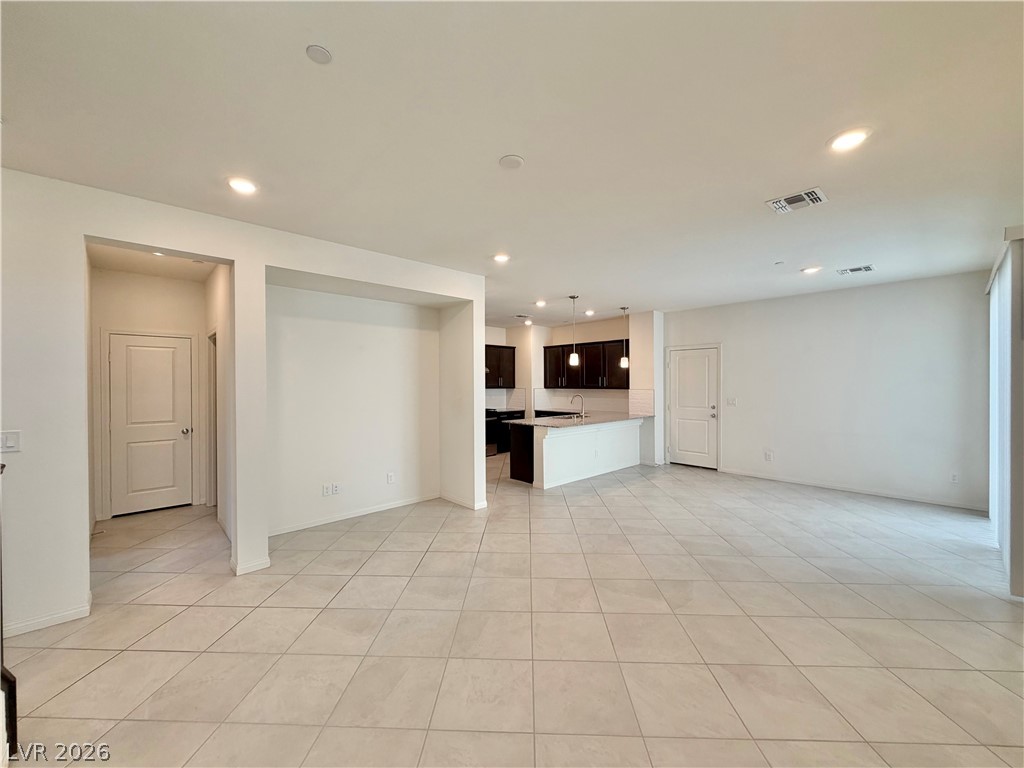3624 Bitonto Lane Henderson, NV 89044 - Photo 28 of 28 This spacious open floorplan seamlessly connects living and kitchen areas, featuring elegant tile flooring throughout.
