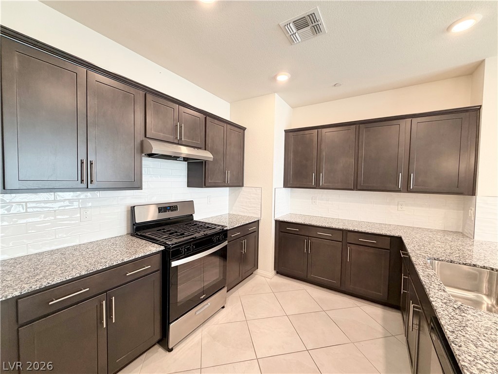 3624 Bitonto Lane Henderson, NV 89044 - Photo 5 of 28 This modern kitchen features elegant dark cabinetry and sleek stainless steel appliances.