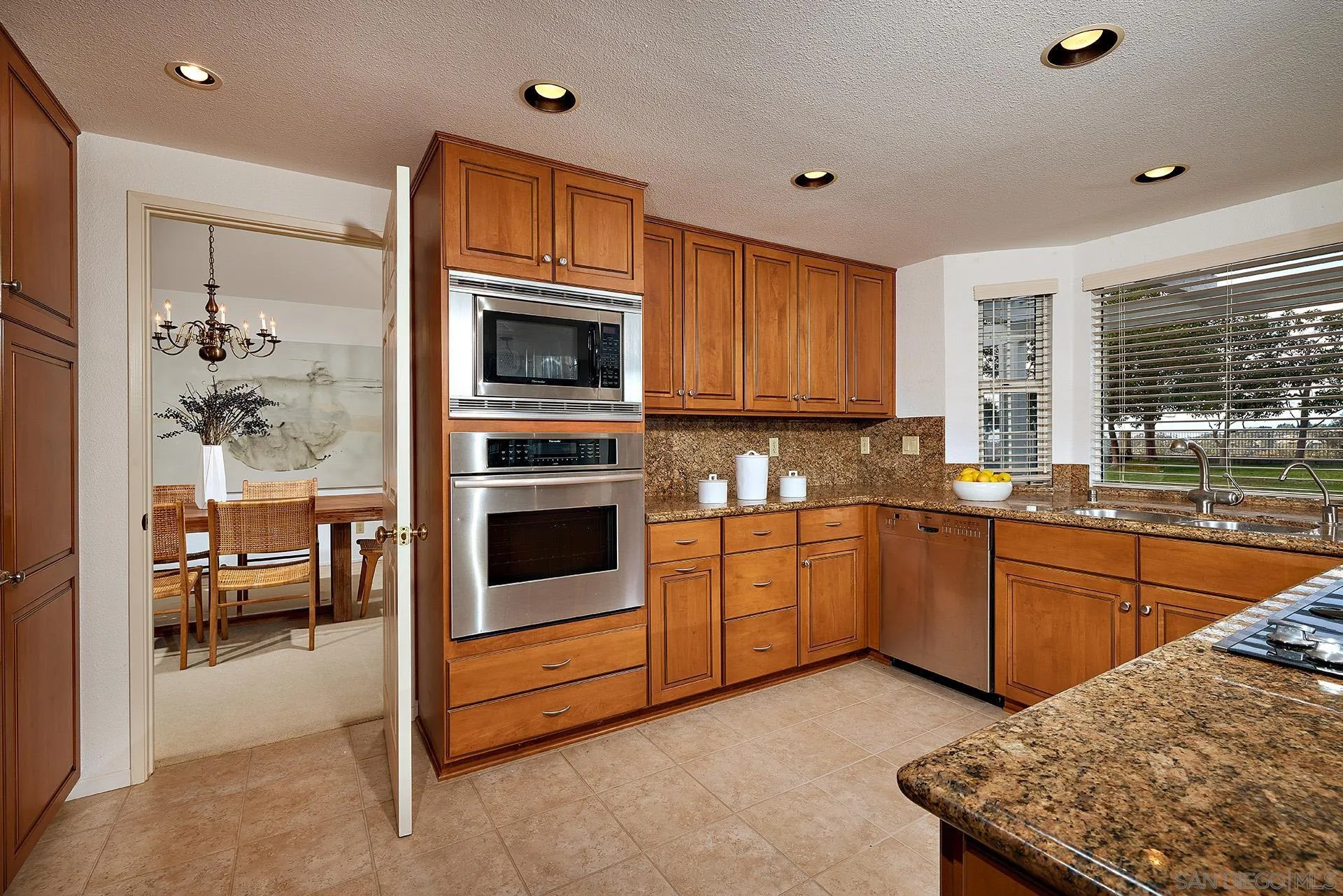 12490 Rue Cheaumont San Diego, CA 92131 - Photo 31 of 58 a kitchen with stainless steel appliances granite countertop a stove a sink and a microwave
