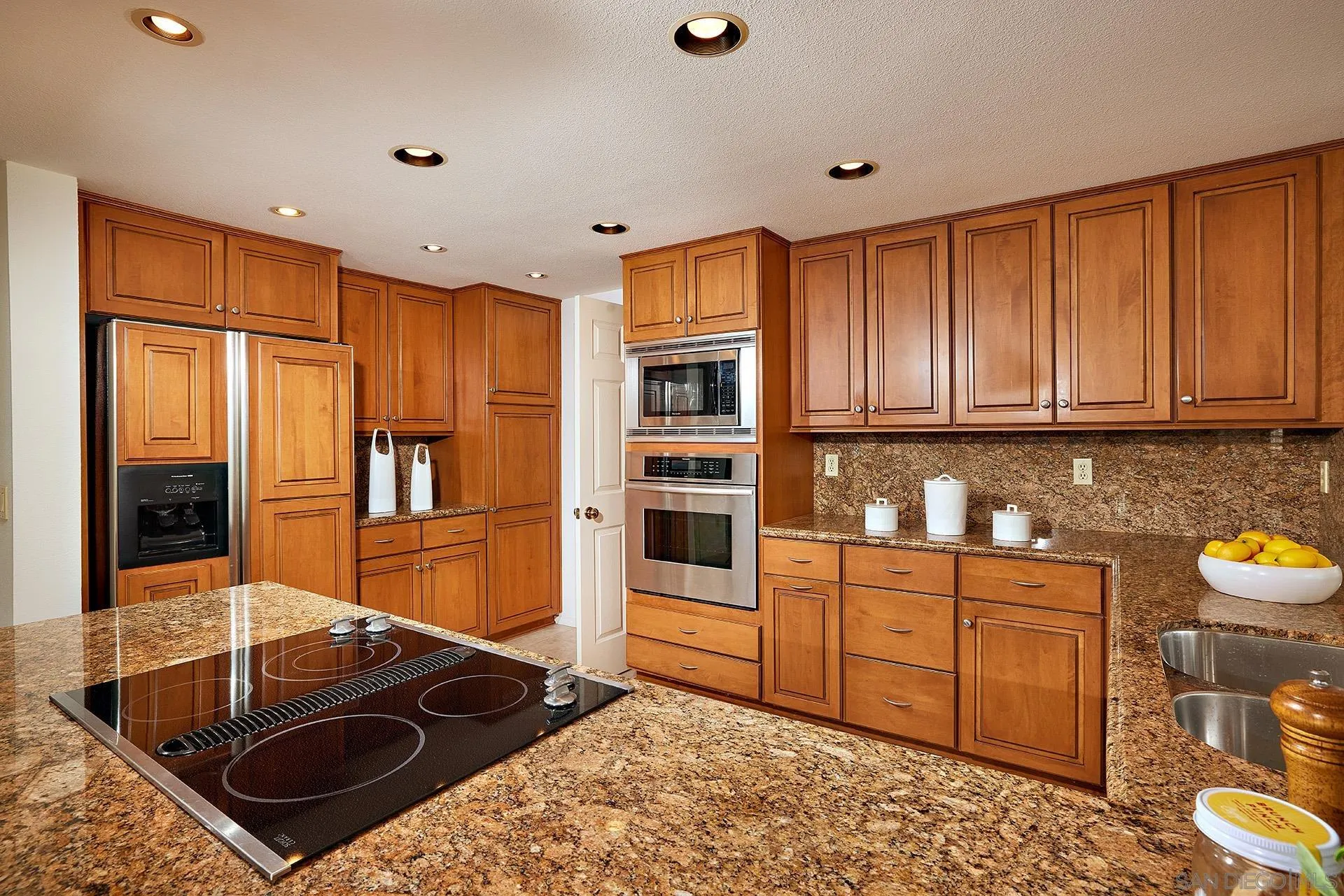 12490 Rue Cheaumont San Diego, CA 92131 - Photo 32 of 58 a kitchen with granite countertop a stove and a sink