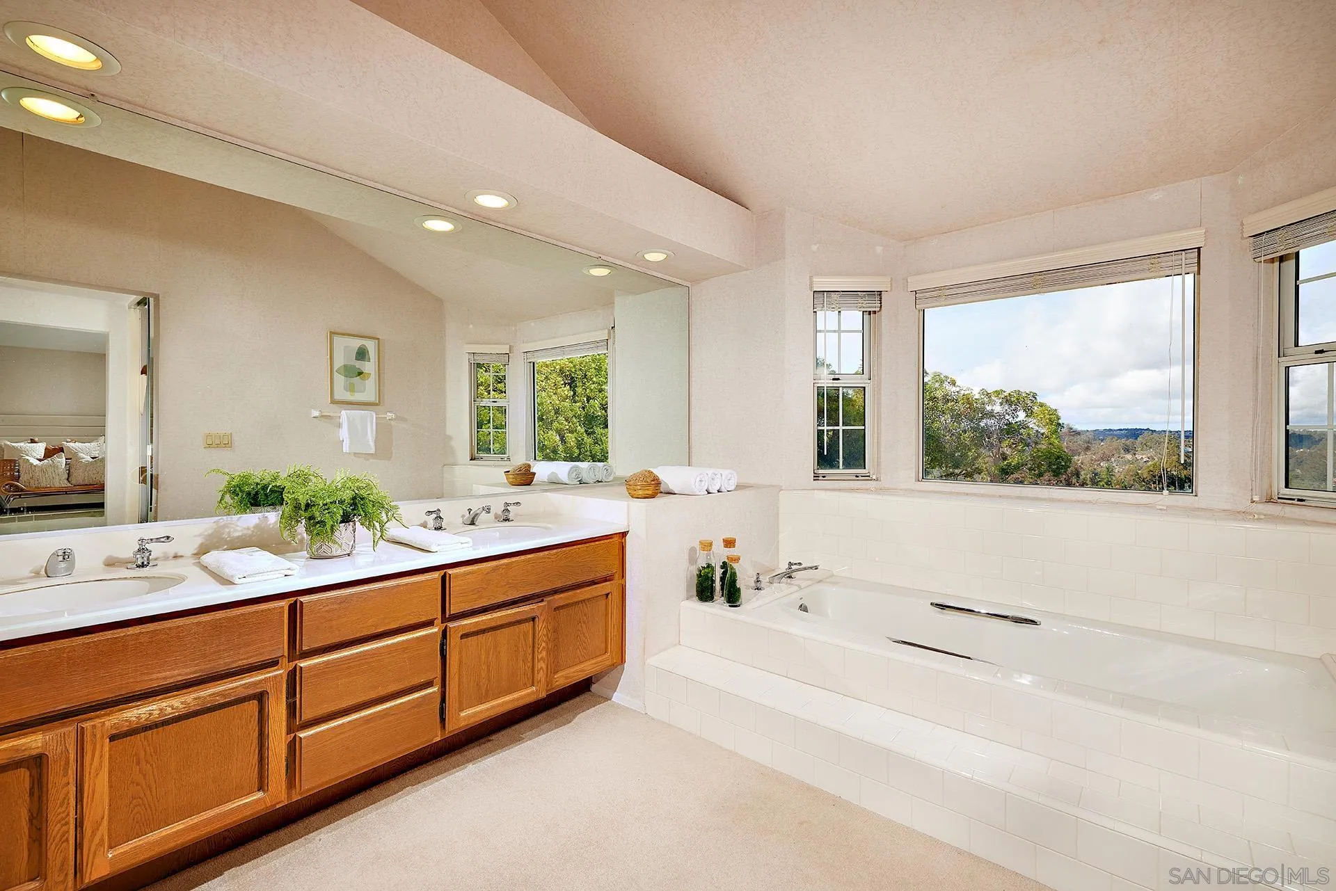 12490 Rue Cheaumont San Diego, CA 92131 - Photo 35 of 58 a spacious bathroom with stainless steel appliances double vanity and a large mirror