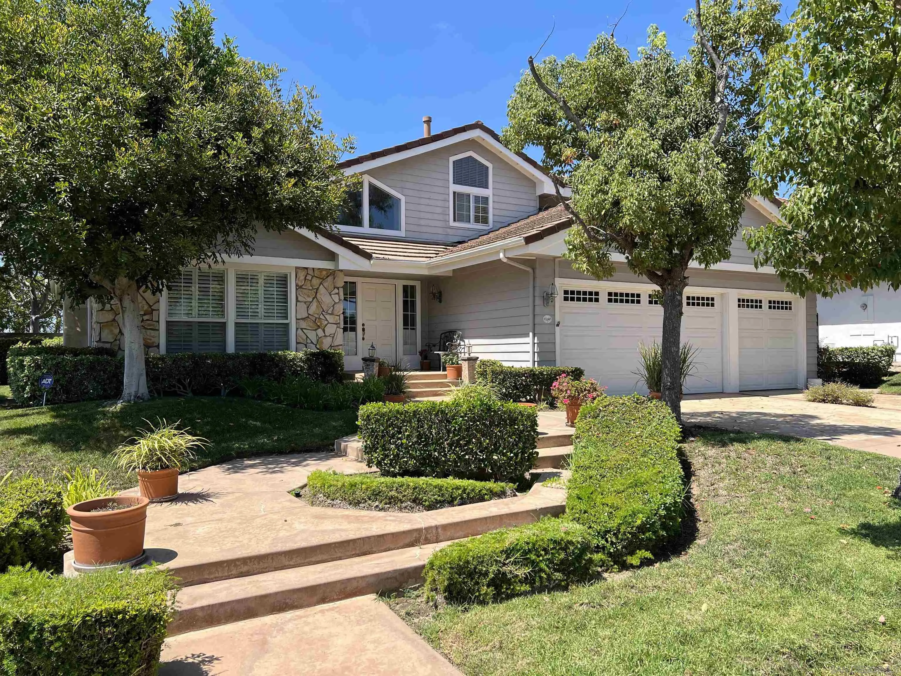 12490 Rue Cheaumont San Diego, CA 92131 - Photo 58 of 58 a front view of a house with a yard and potted plants
