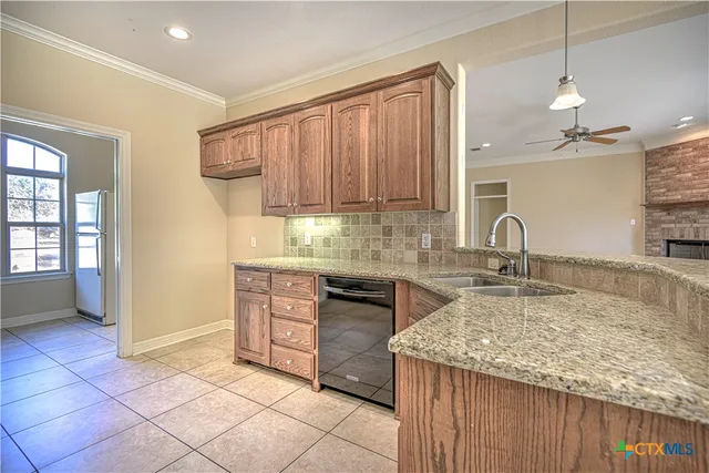 a large white kitchen with a large counter top and stainless steel appliances