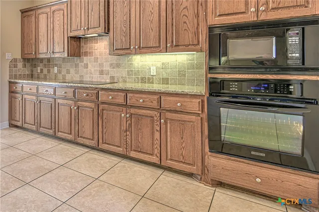 a kitchen with granite countertop a sink and a wooden cabinets