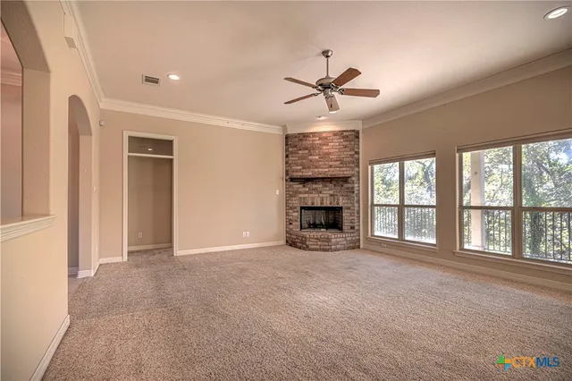 a view of an empty room with a fireplace and a window