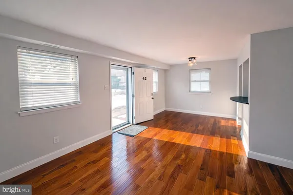 a view of empty room with wooden floor